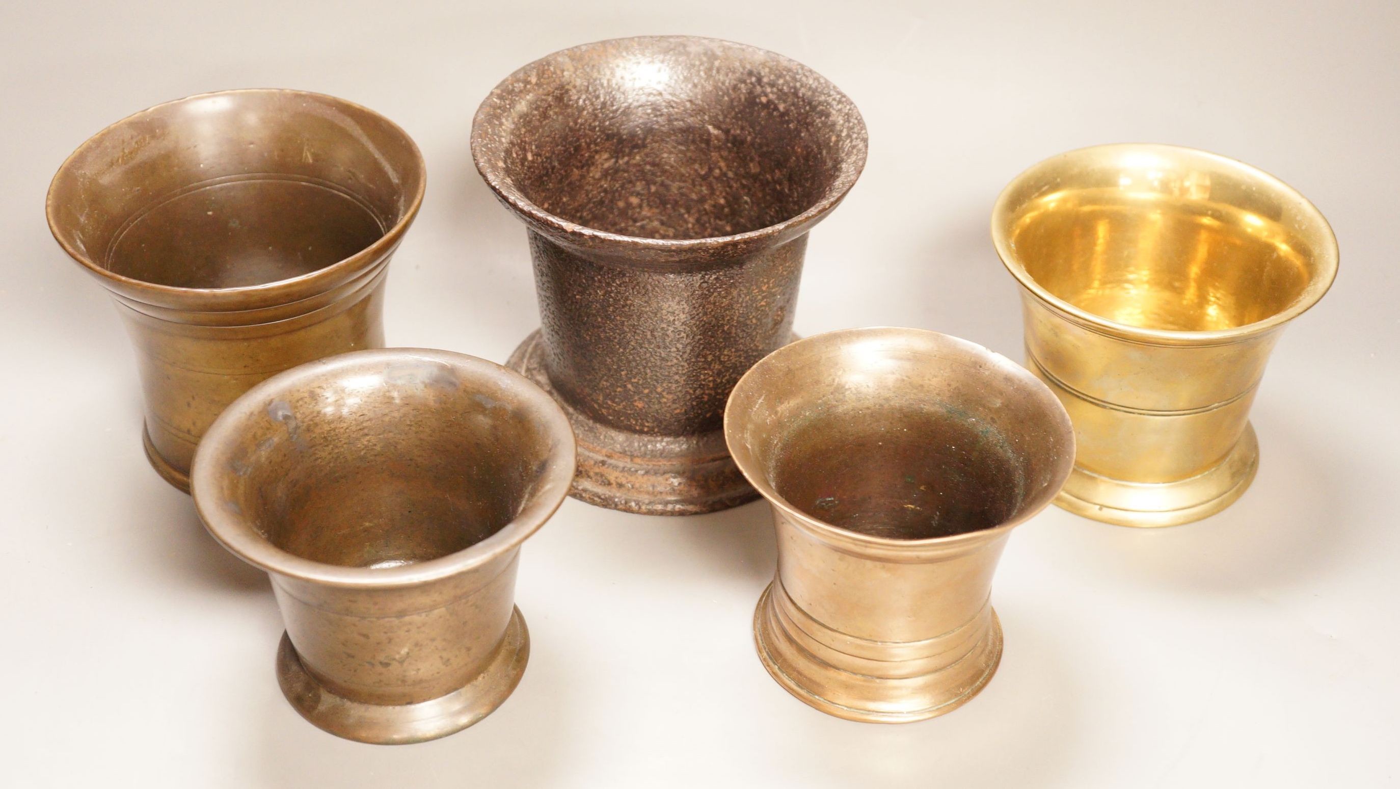 A group of four various bronze mortars and a similar cast-iron example, Largest 13 cm high